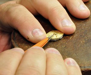 Norman-Hege-Jewelers-jewelry-repair Norman Hege Jewelers | A pair of hands using a tool to do jewelry repair on a watch
